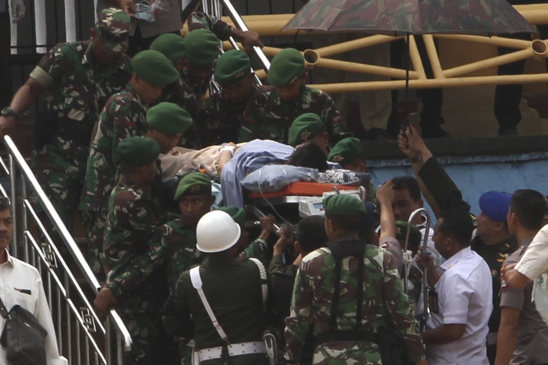 Soldiers carry Indonesian minister Wiranto on a stretcher to a waiting helicopter to be evacuated to Jakarta, in Pandeglang, Banten province. Photo: AP
