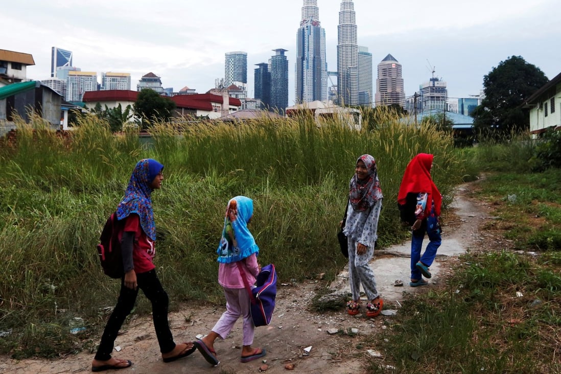 Girls make their way home after school in Kuala Lumpur, Malaysia. Photo: Reuters