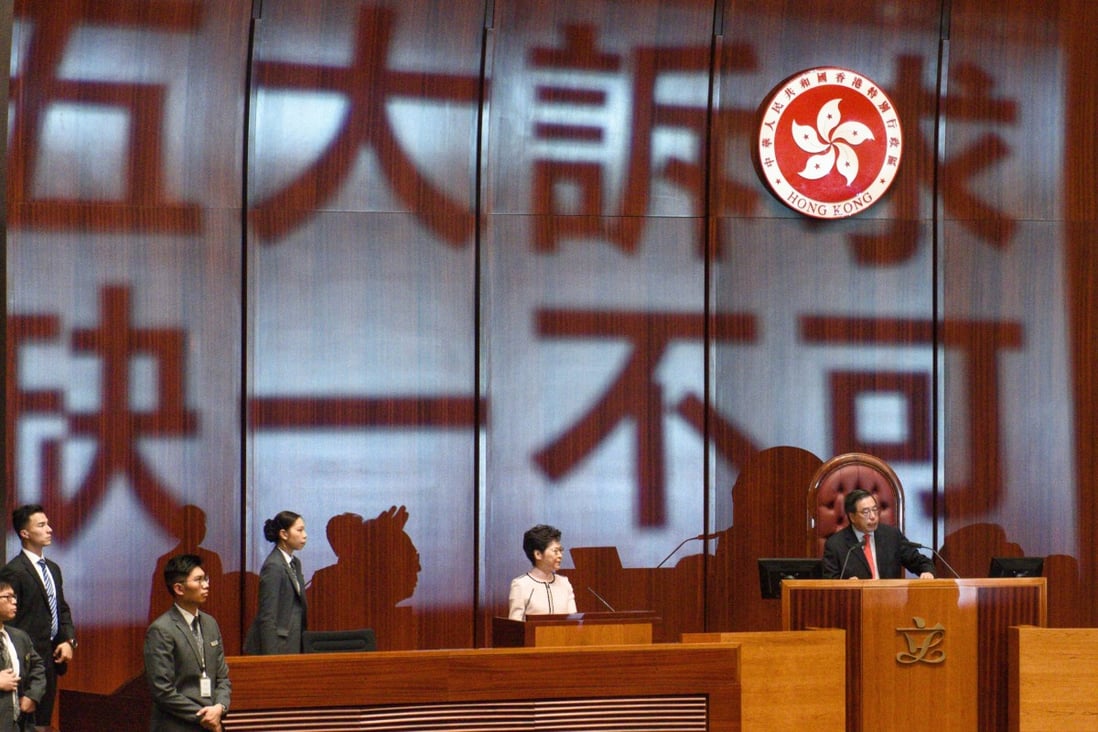 The words: “Five demands, not one less”, are projected by pro-democracy lawmakers onto the wall behind Chief Executive Carrie Lam as she prepares to deliver her policy address in the Legislative Council in Hong Kong, on October 16. Photo: EPA-EFE