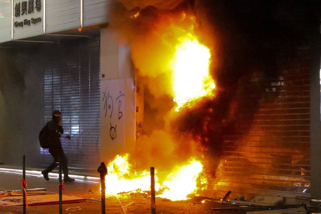 A shop selling smartphones made by Chinese company Xiaomi was torched by hard-core protesters, before a thief took advantage of the chaos. Photo: Felix Wong