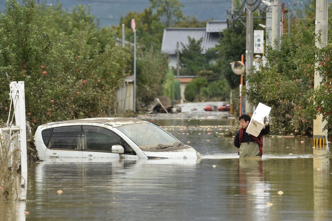 A man in Nagano wades through floodwaters in the aftermath of Typhoon Hagibis. Photo: AFP