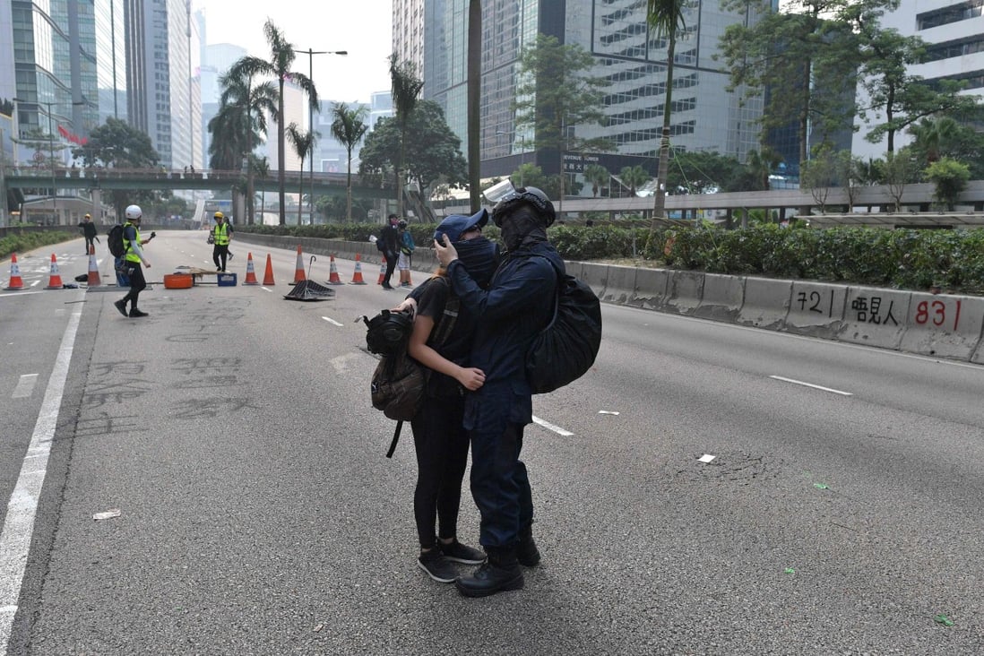 A tender moment between protesters in the middle of a blocked road following an unsanctioned march through Hong Kong on September 29. Photo: AFP