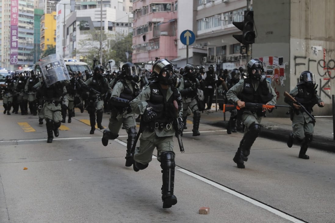 Police chase away protesters in Hong Kong on Sunday as unrest continued for a 20th successive weekend. Photo: AP
