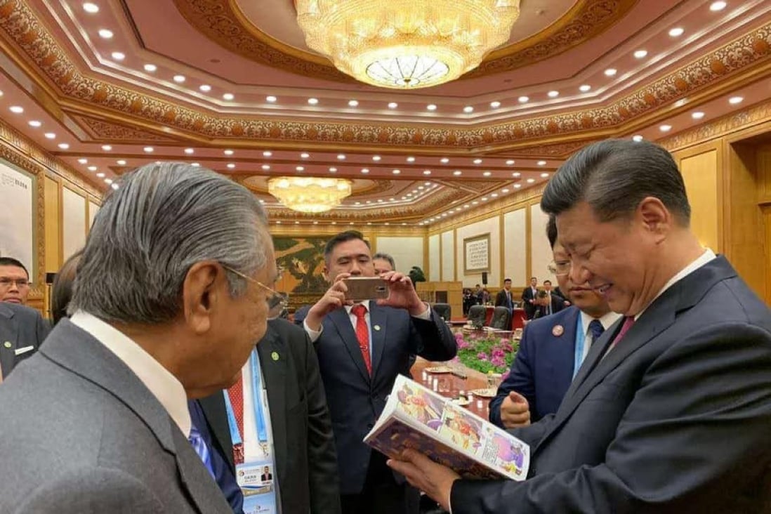 Chinese President Xi Jinping reads the controversial belt and road comic as Malaysian Prime Minister Mahathir Mohamad looks on. Photo: Facebook/Hew Kuan Yau