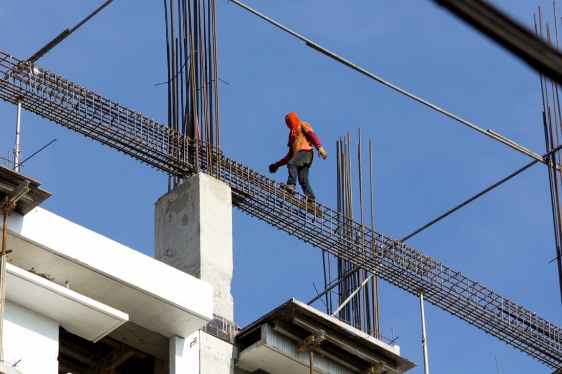 A worker fearlessly walks along steel reinforcement bars at a construction site in Manila. Photo: Getty Images/iStockphoto