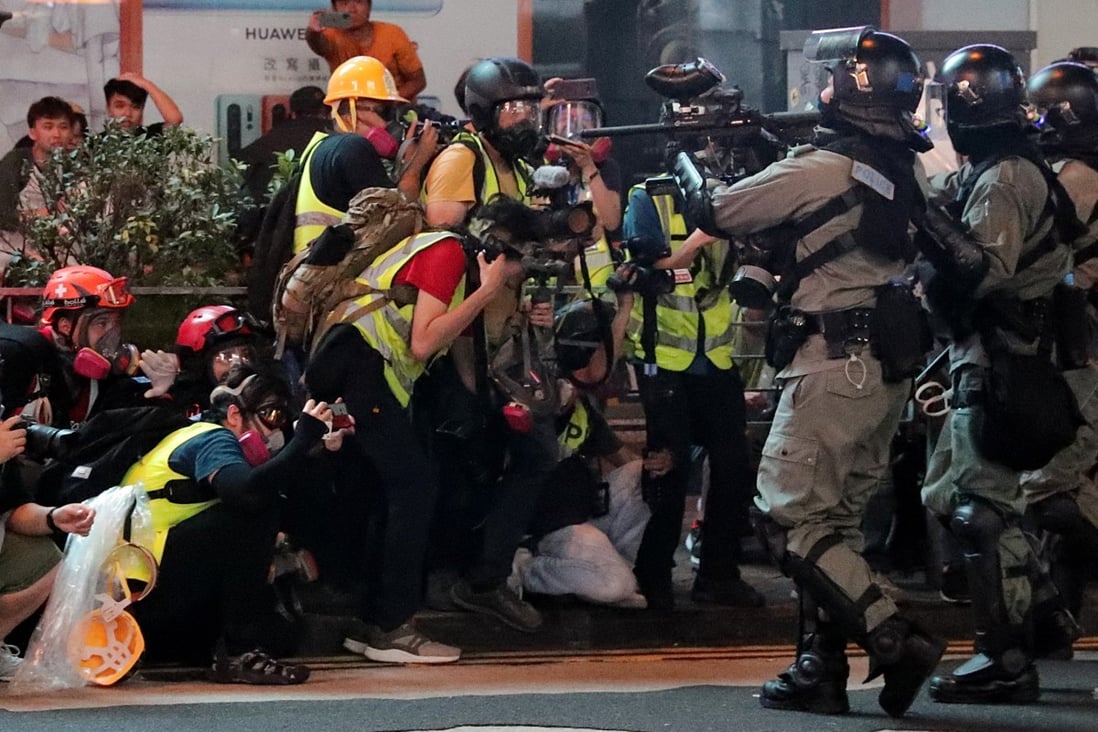Riot police march up against a group of journalists during clashes with protesters in Mong Kok on Sunday. Photo: Edmond So