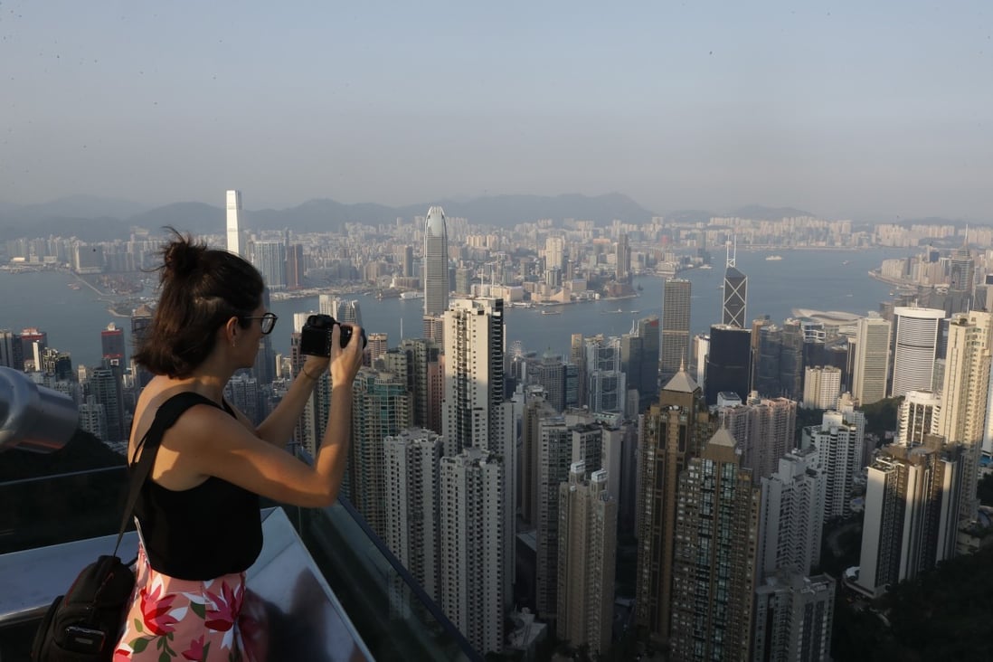 A tourist takes a photograph of Hong Kong's skyline from Victoria Peak, a popular destination for travellers to the city. Photo: EPA-EFE
