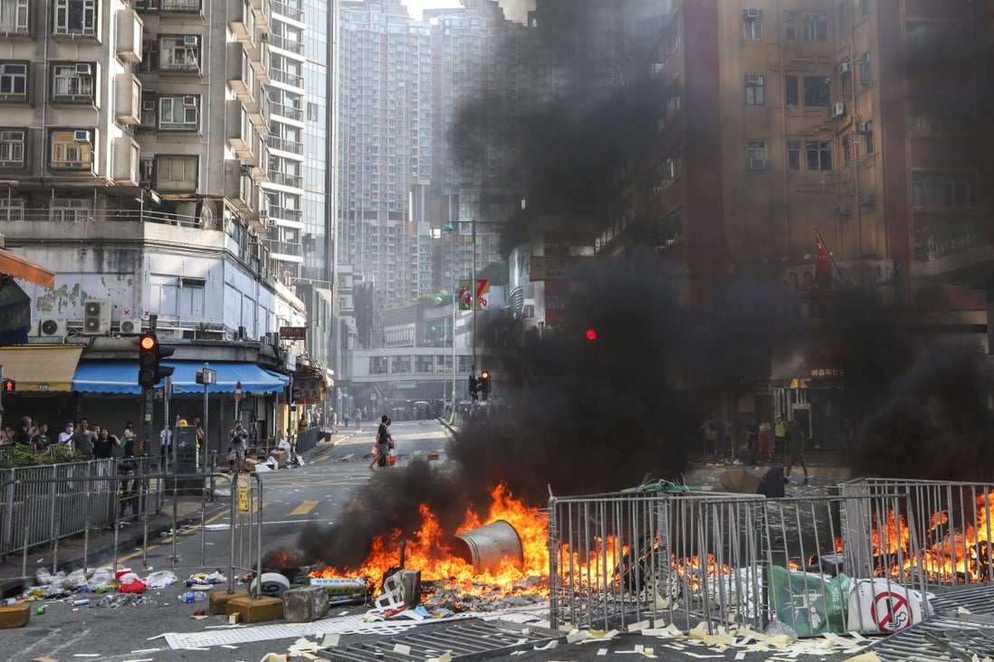Barricades are set on fire in Tuen Mun during a mass protest. The decline in home prices in September was larger than the 1.4 per cent drop recorded in August. Photo: Xiaomei Chen
