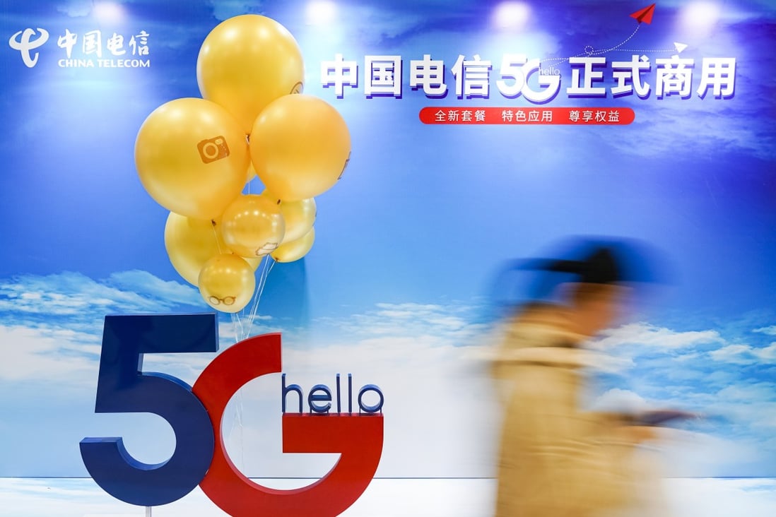A consumer walks past a poster promoting 5G mobile applications outside a branch of China Telecom in Beijing on October 31. Photo: Xinhua