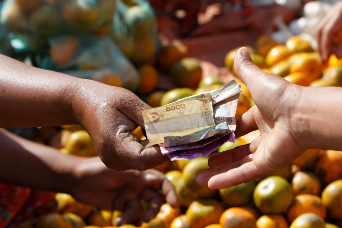 Money changes hands at a market in Lombok, Indonesia. In Indonesia, the left hand is traditionally the one used to clean yourself after going to the toilet. Photo: Alamy