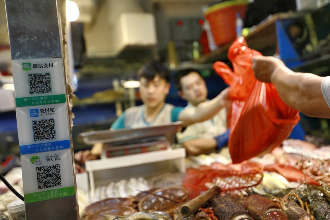 Cashless payment platforms through smartphone-enabled QR codes are ubiquitous in China, expanding to a US$12.8 trillion market by the end of October in 2017. Ant Financial’s Alipay and Tencent’s WeChat Pay are the two dominant service providers. Here a seafood hawker in Beijing announces he accepts both payment methods. Photo: EPA