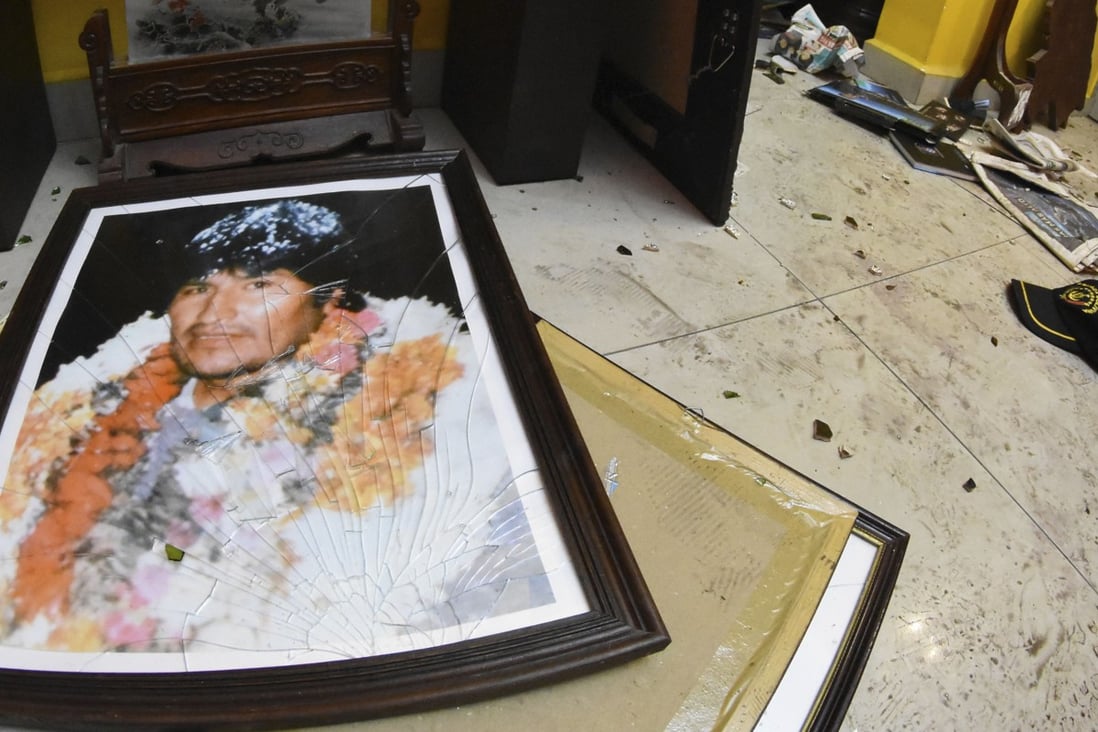 A broken portrait of former Bolivia's President Evo Morales, who resigned on Sunday. Photo: AP