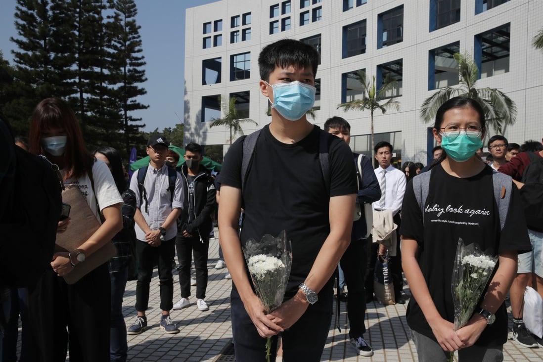 Protesters holding flowers to remember Chow Tsz-lok after a graduation ceremony was cut short at the University of Science and Technology on November 8. Chow died after falling from a car park during a police clearance operation. Photo: AP