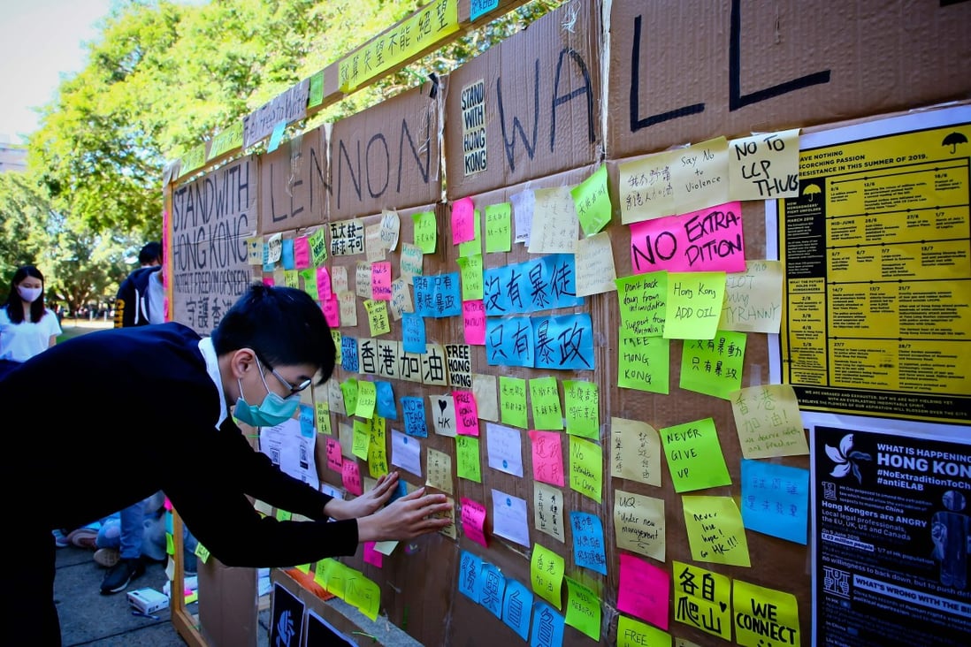 A supporter of Hong Kong’s anti-government protests posts a note on a makeshift ‘Lennon Wall’ at the University of Queensland in Brisbane. Photo: AFP