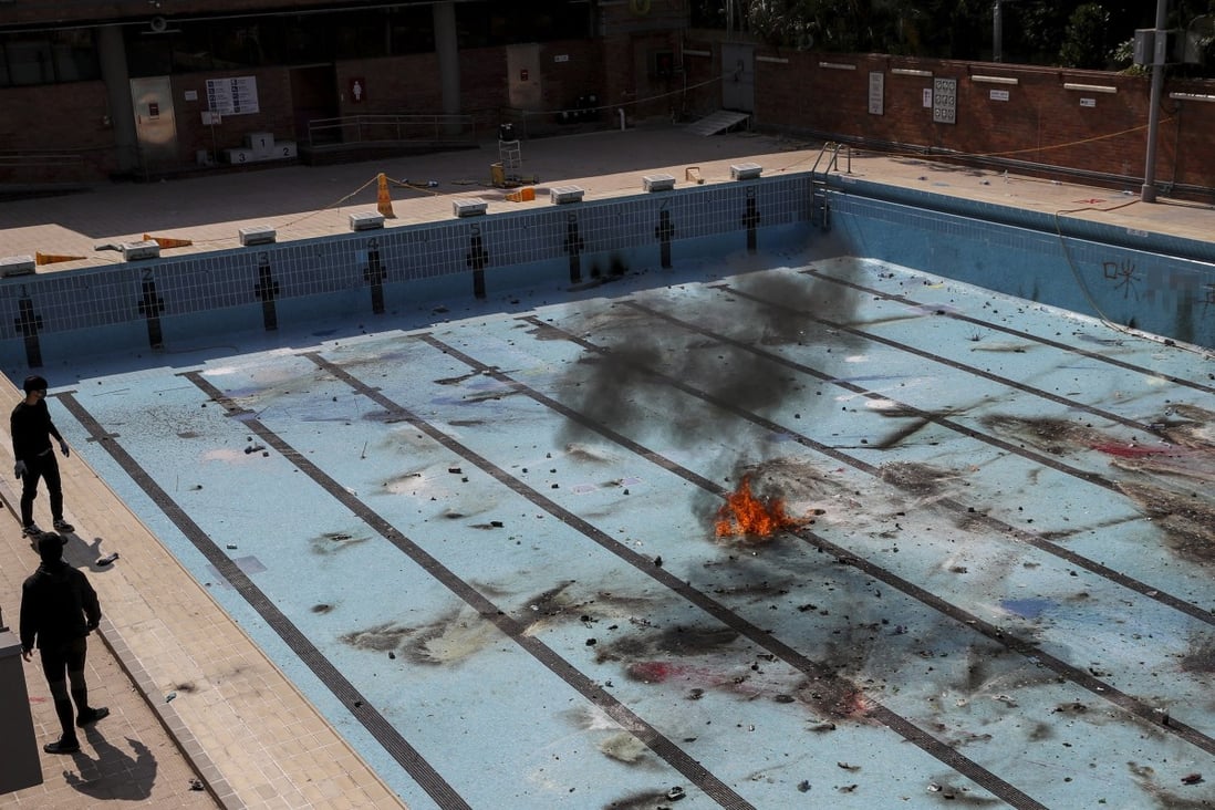 Student protesters at PolyU practise throwing petrol bombs into an empty swimming pool. Photo: Winson Wong