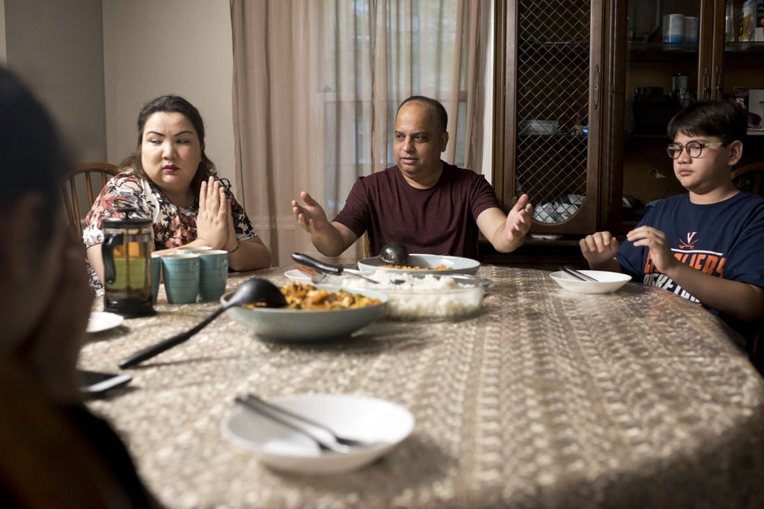 Zumrat Dawut, Imran Muhammad, and their son Danish, 13, prepare to dine at home in Dale City, Virginia, in July. Photo: Washington Post photo by Marlena Sloss