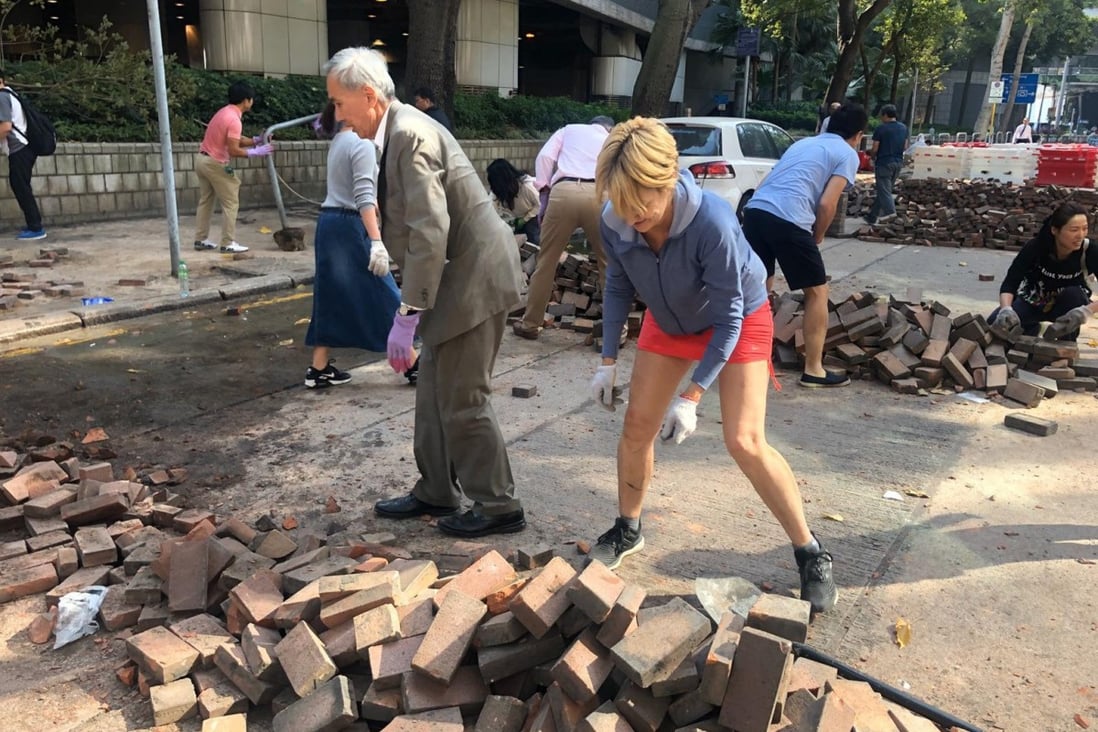 Sino Group chairman Robert Ng helps remove bricks from a road in Tsim Sha Tsui. Photo: Handout