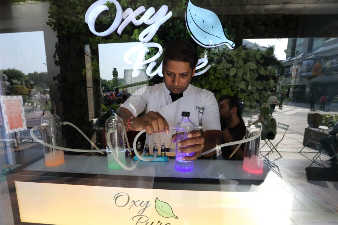 An employee prepares aromatic oxygen flasks at the Oxy Pure bar in New Delhi. Photo: EPA