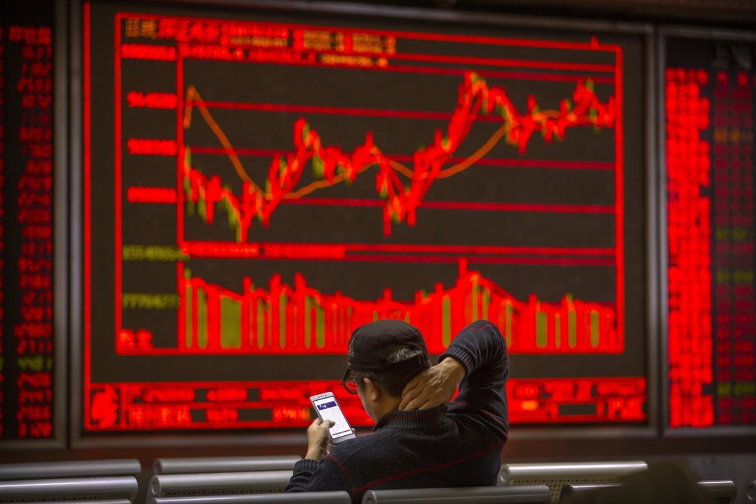 A Chinese investor uses his smartphone to monitor stock prices at a brokerage house in Beijing on November 19, 2019. Photo: Associated Press