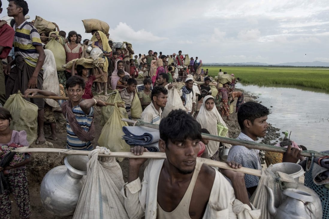Rohingya refugees walk with their belongings after crossing the Naf river from Myanmar into Bangladesh in 2017. Photo: AFP