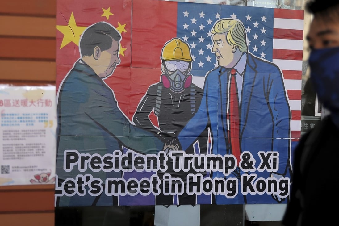 A pro-democracy student walks past a poster featuring Chinese President Xi Jinping and US President Donald Trump on the campus of the University of Hong Kong this month. Photo: AP