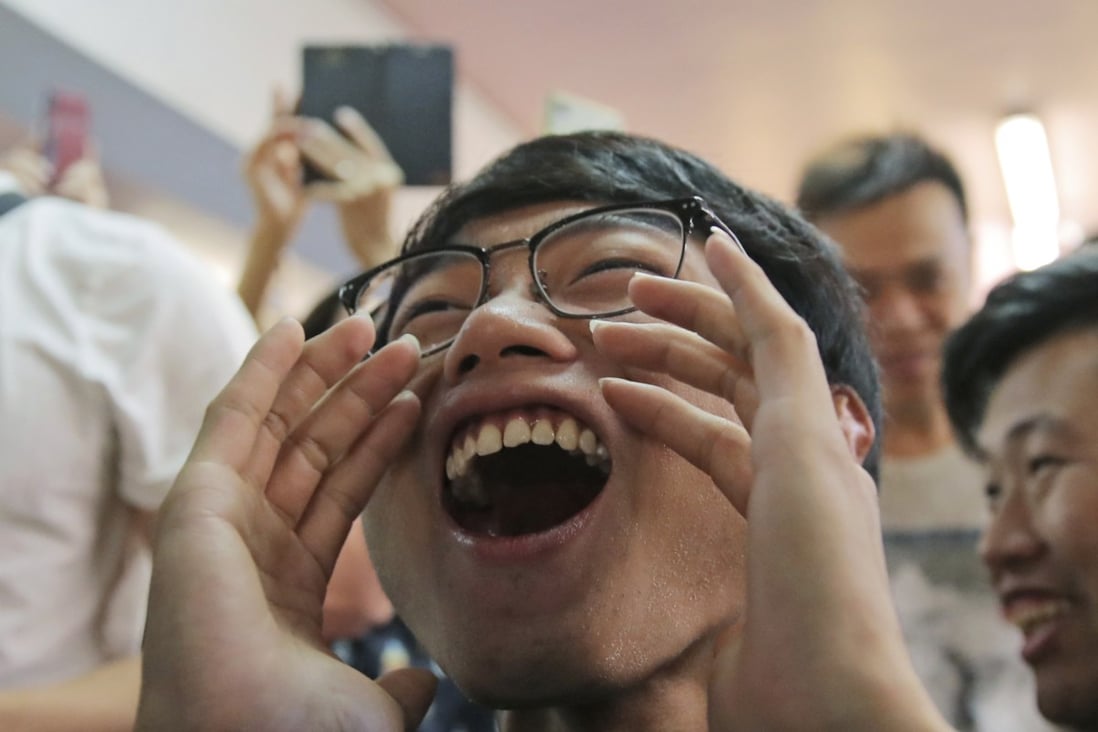 Pro-democracy supporters celebrate after a pro-Beijing politician loses his bid for a district council seat in Hong Kong early Monday. Photo: AP