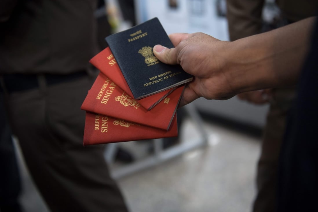 A Thai immigration officer displays fake passports in Bangkok. Photo: AFP