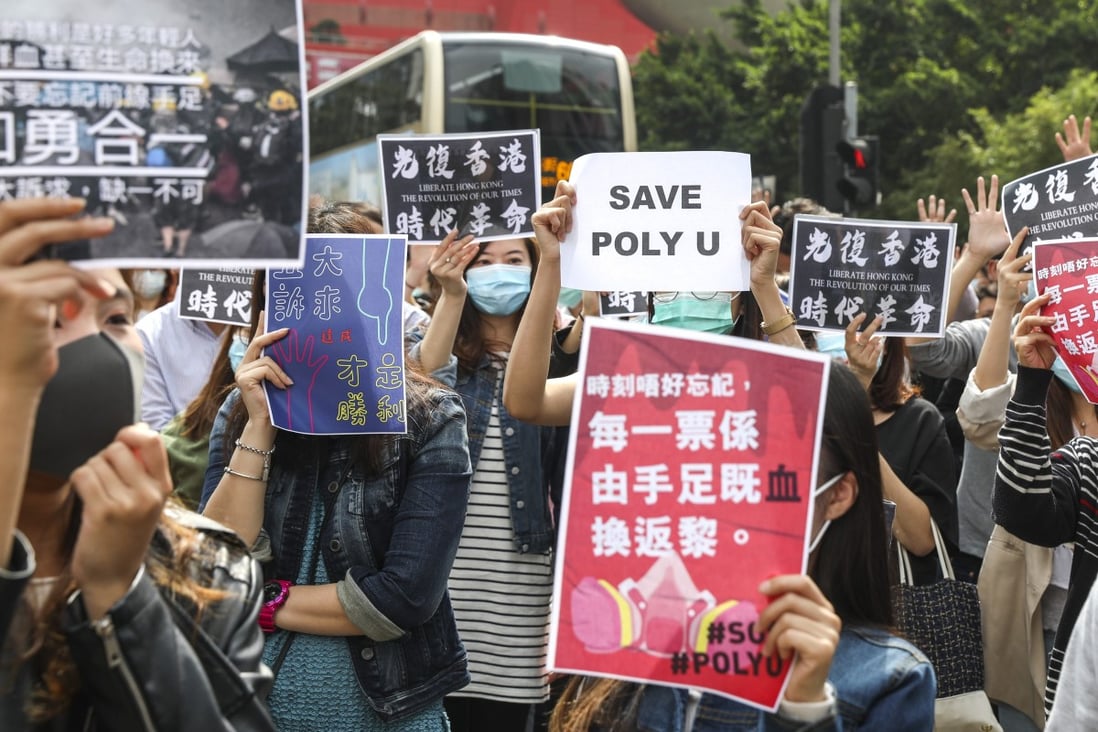 Protesters at a lunchtime rally in Kowloon Bay on November 26, holding signs saying “Save PolyU”, “Don’t forget the bloody price behind every vote” and “True victory is when all five demands are met”. Photo: Nora Tam