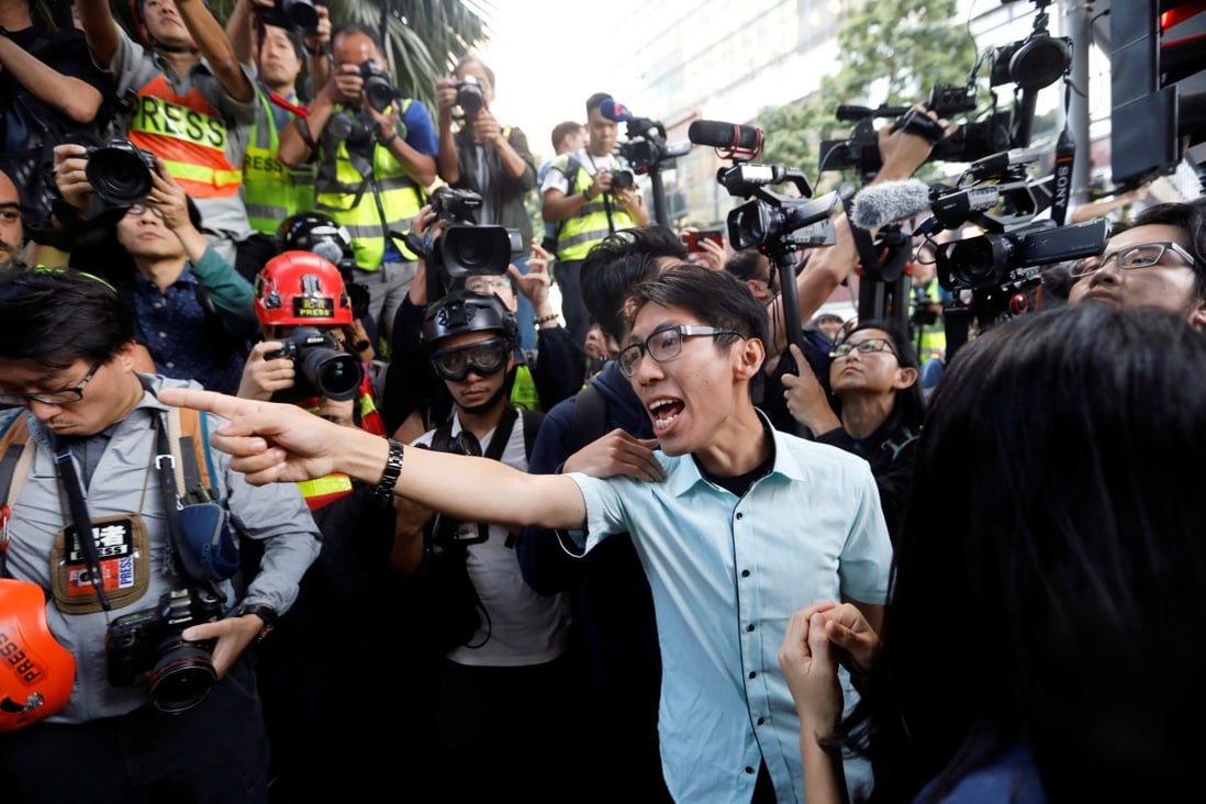 Ng Kin-wai, a victorious pan-democratic candidate in the district council elections, argues with police officers as they walk towards the Polytechnic University campus on November 25. Photo: Reuters