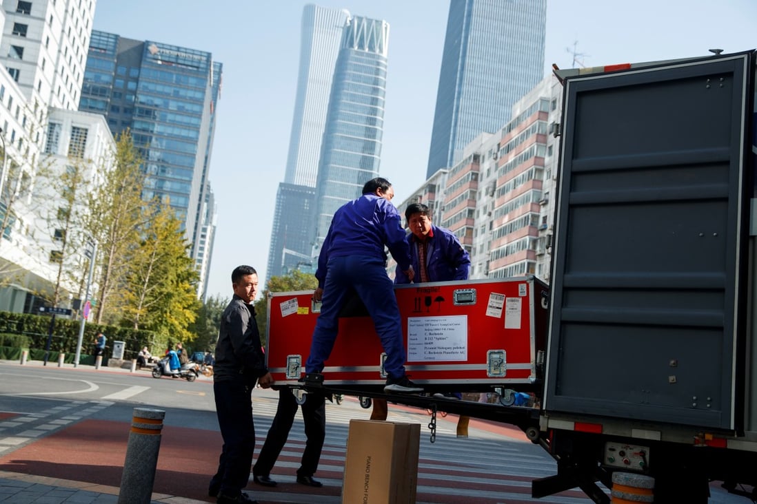 Workers unload cargo from a truck in the central business district in Beijing in October this year. Photo: Reuters