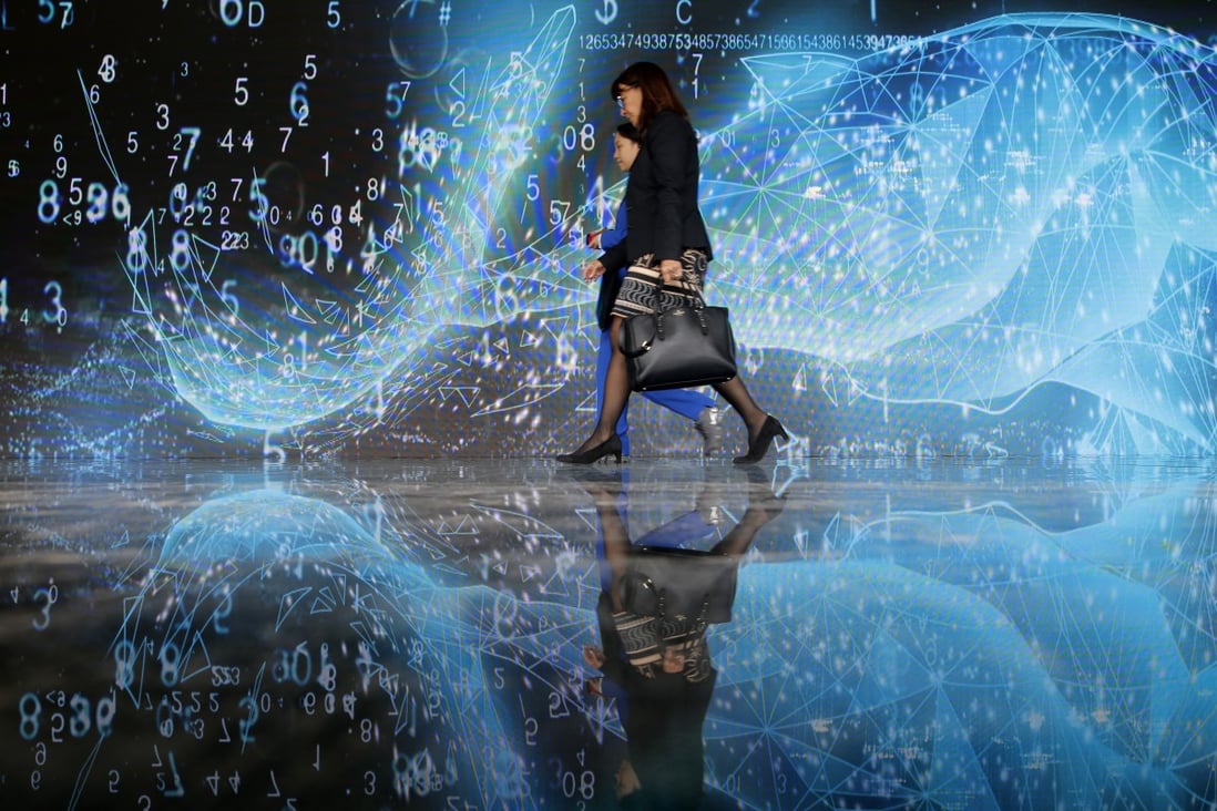 Visitors walk past a screen at the 6th World Internet Conference in Wuzhen, China, on October 21. More cooperation, not decoupling, is needed as the world embarks on its fourth industrial revolution. Photo: EPA-EFE