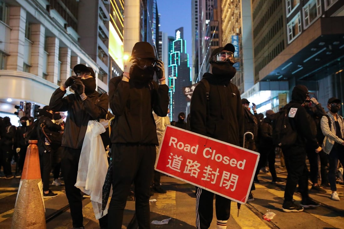 Black-clad protesters occupy a section of Des Voeux Road in Central on December 8, engaging in a standoff with riot police that continued into the evening. Photo: Winson Wong