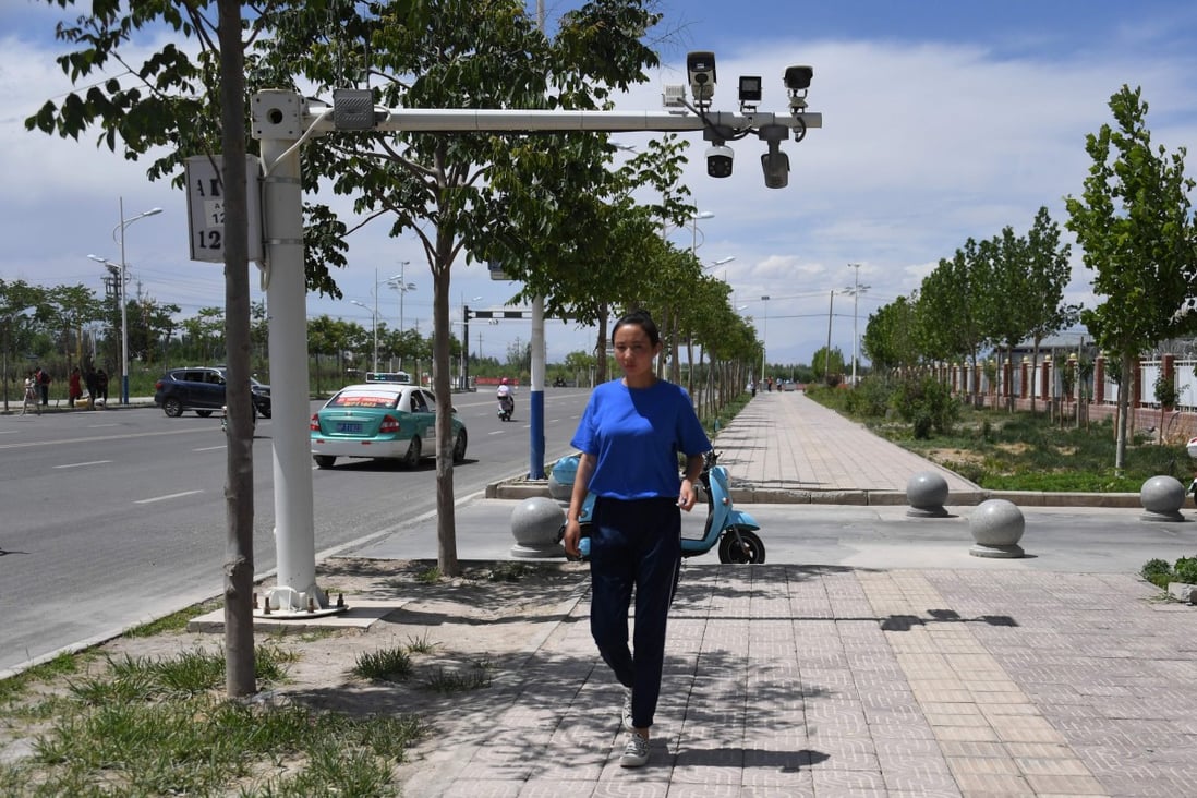 A woman walks below surveillance cameras in Akto, south of Kashgar, in China's western Xinjiang region, on June 4, 2019. Photo: AFP