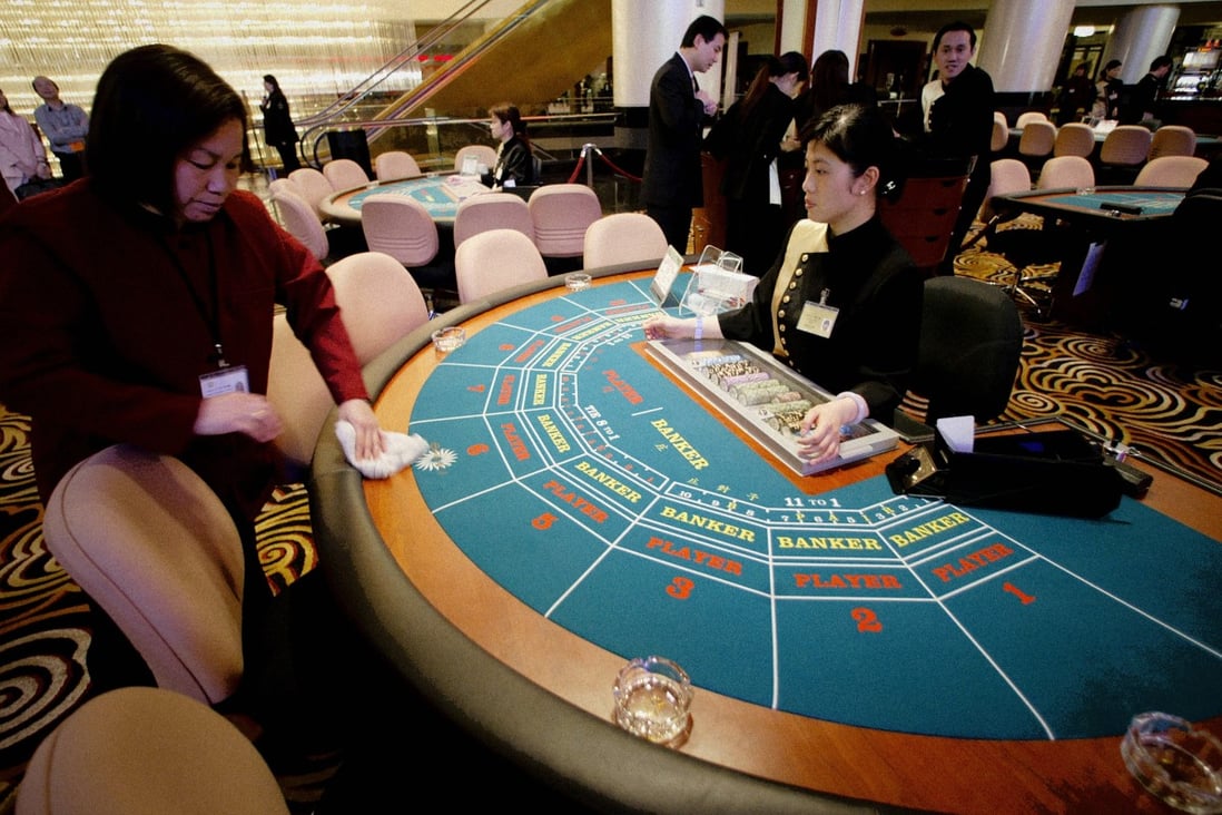 A cleaner wipes down a gambling table just before the opening of the new Sands Casino in Macau on 18 May 2004. Sands is the first American operator of gambling facilities in the Chinese Special Administrative Region (SAR). Photo: AFP