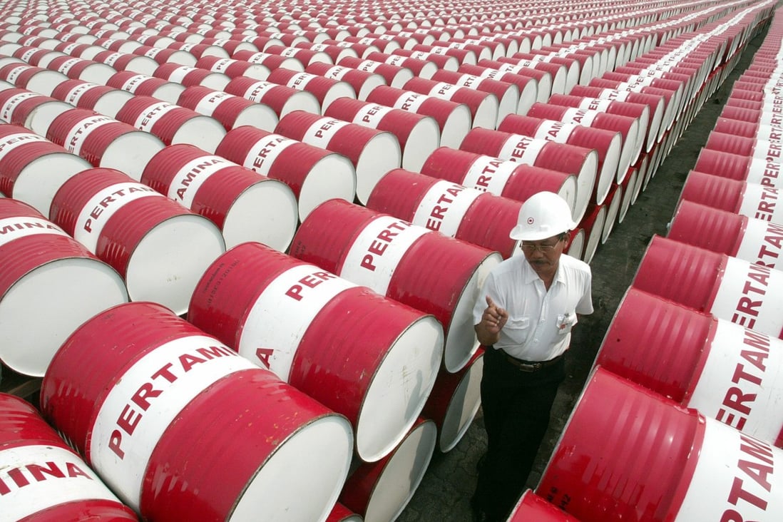 An employee of Indonesia’s state-owned oil company Pertamina walks past oil drums at the company’s main depot in north Jakarta. Photo: Reuters