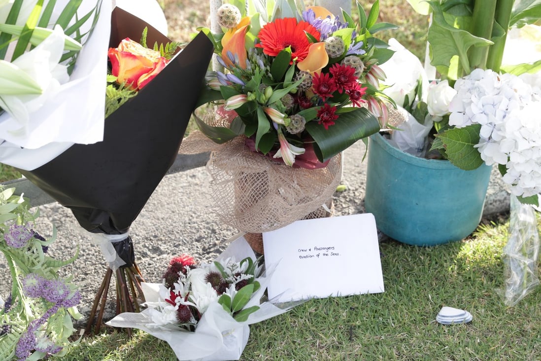 Floral tributes to the volcano’s victims lie at the port in Tauranga, where the cruise ship Ovation of the Seas is berthed. Photo: EPA