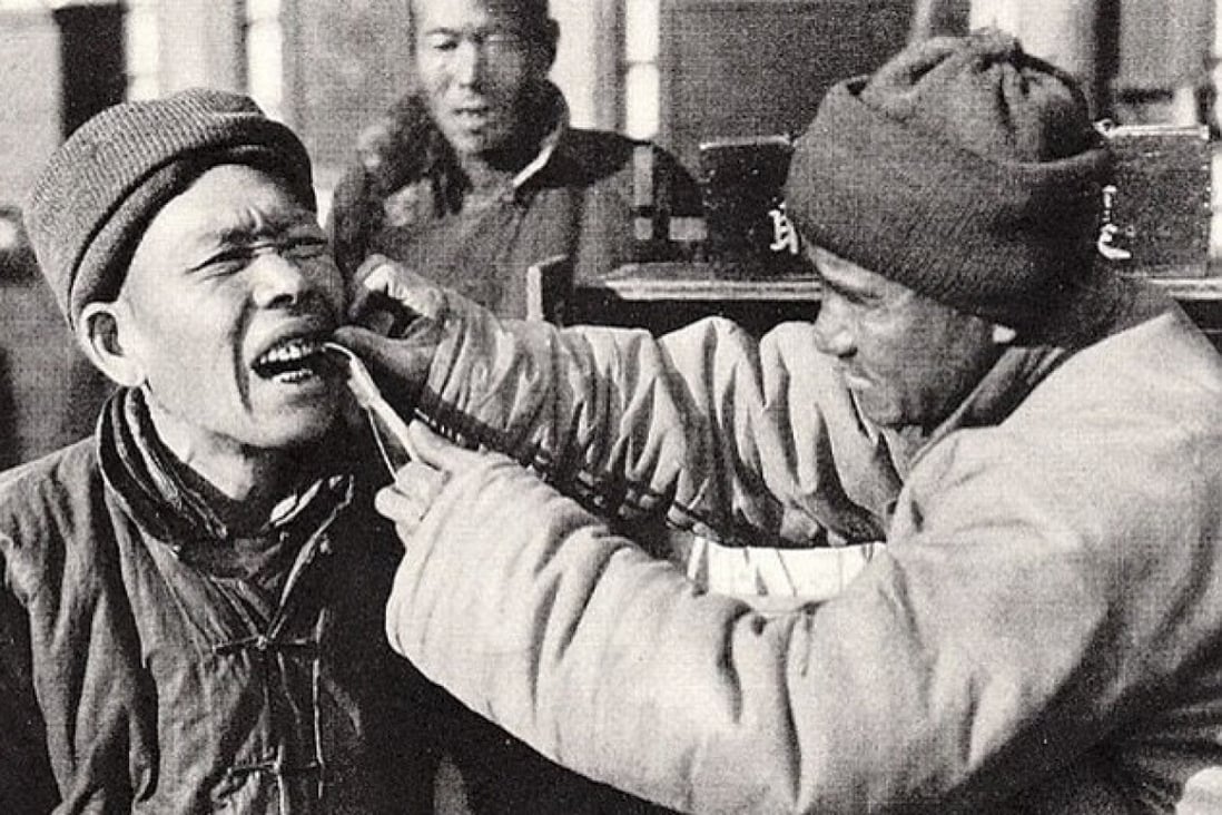 A dentist in China performs a tooth extraction in the 1920s.