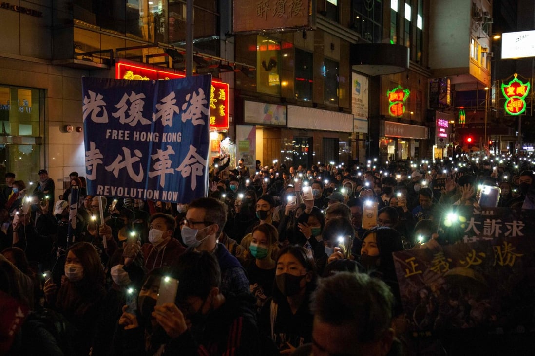 A man holds a banner that reads in Chinese, “Liberate Hong Kong, revolution of our times" during a rally in Wan Chai on December 8. Photo: AFP