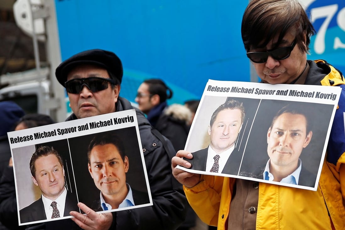 People hold placards calling for China to release Michael Spavor and Michael Kovrig outside a court hearing for Huawei executive Meng Wanzhou in Vancouver in March. Photo: Reuters