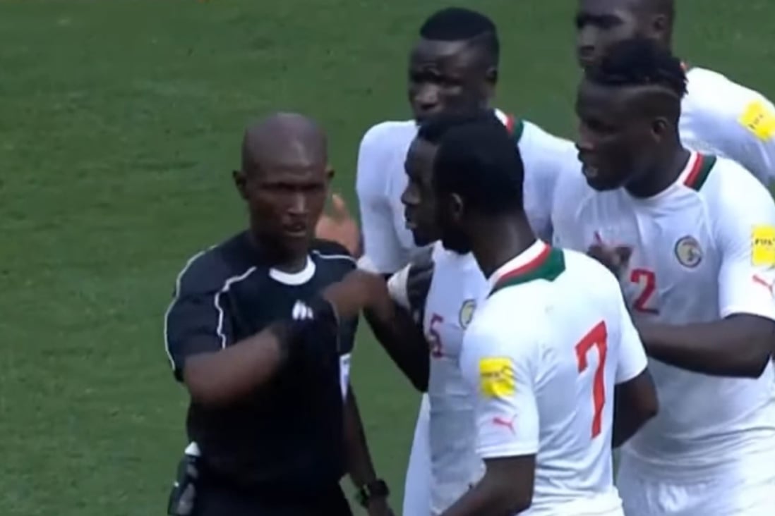 Joseph Lamptey is surrounded by Senegal players after awarding South Africa a penalty. Photo: YouTube