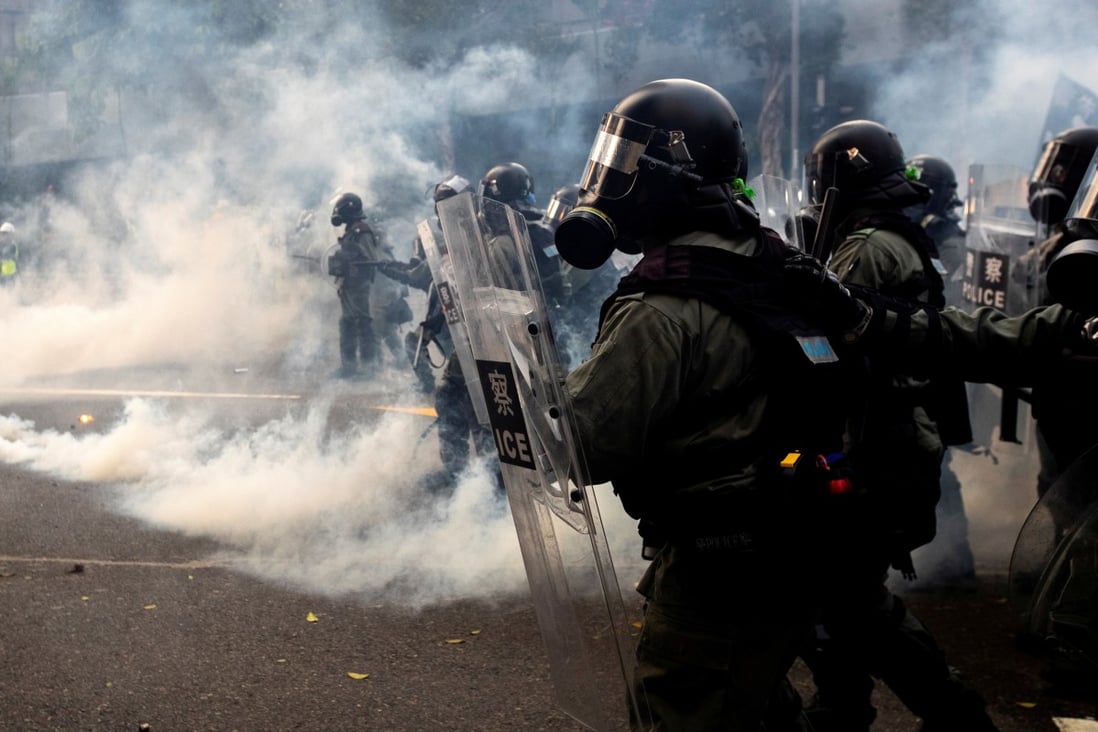 Hong Kong riot police officers fire tear gas during a protest in the Admiralty district of Hong Kong. Photo: Reuters