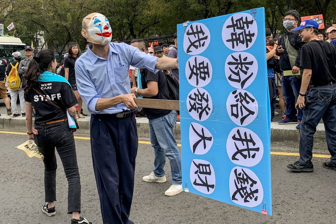 A campaigner wears a clown mask and carries slogans mocking Han Kuo-yu. Photo: Sarah Zheng