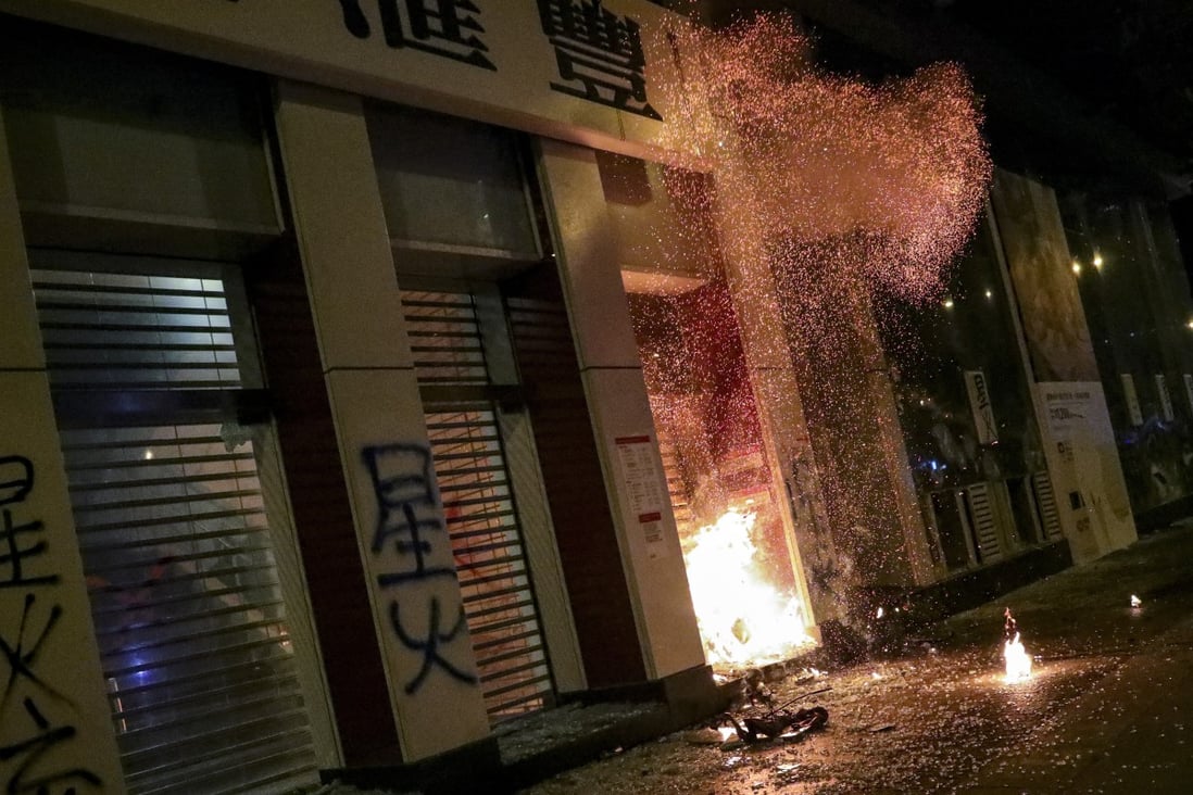 Protesters smashed the glass walls of HSBC’s Mong Kok branch on Christmas Eve and started a fire at its entrance. Photo: May Tse