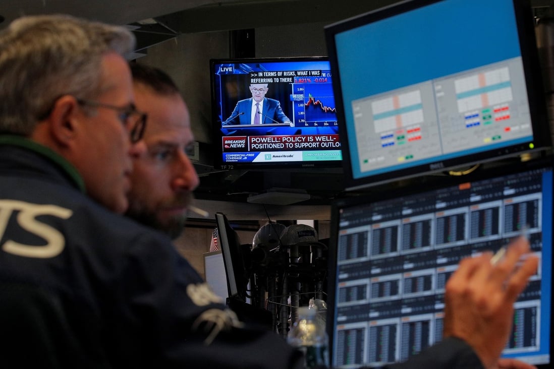 Traders work at the New York Stock Exchange as a screen shows US Federal Reserve chairman Jerome Powell’s press conference after the central bank announced it would cut interest rates for the third time this year, on October 30. Photo: Reuters