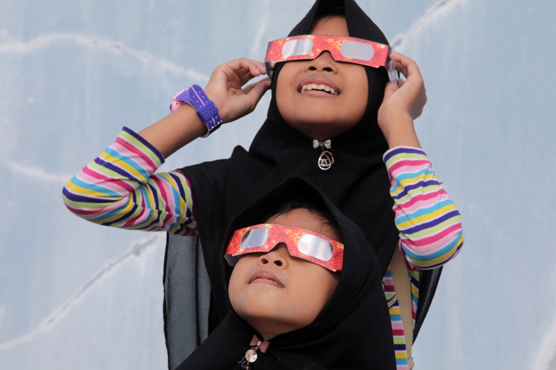 Children wear special glasses to look at a solar eclipse in Banda Aceh, Indonesia on December 26, 2019. Photo: EPA-EFE