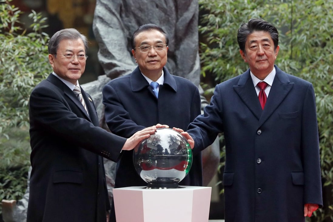 From left, South Korean President Moon Jae-in, Chinese Prime Minister Li Keqiang and Japanese Prime Minister Shinzo Abe pose for a photo during a ceremony to mark 20 years of trilateral cooperation during the Asian trilateral summit. Photo: dpa