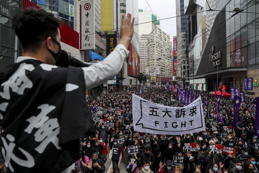 A protesters holds up a hand, to symbolise the movement’s five demands, during a march on New Year’s Day in Causeway Bay. The five demands include democratic elections for Hong Kong’s leader and legislature, and a probe into police behaviour during the six months of protests. Photo: Sam Tsang