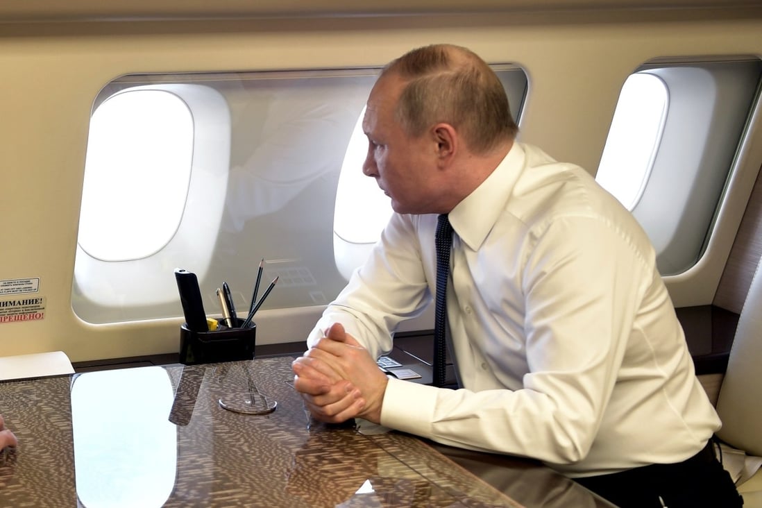 Russian President Vladimir Putin looks through the windows of his plane while flying over Syria. Photo: AP