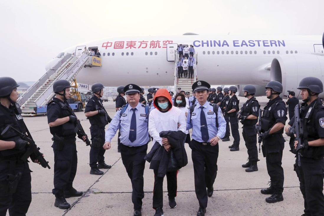 Police escort criminal suspects as they get off a plane in Beijing, Friday, June, 7, 2019. A group of 94 Taiwanese accused of telephone and online fraud arrived at Beijing airport after being extradited from Spain, Chinese authorities said. Photo: Xinhua via AP