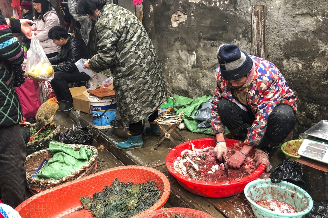 A man cuts up a fish in a wet market in Wuchang, Wuhan city, Hubei province. Photo: Simon Song